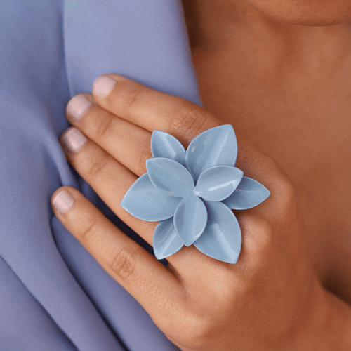 An elegant blue porcelain flower ring, featuring intricate petal details and a delicate design.
