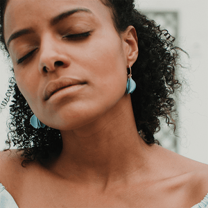 Natural light. Woman wearing blue porcelain earrings. Minimal and modern jewellery. 
