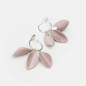 Delicate porcelain earrings. Statement earrings with a gloss glaze finishing. Silver hoops. Light grey background. 