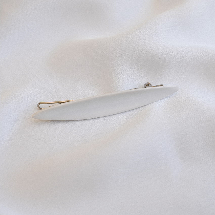 White porcelain hairpin. Delicate piece on a soft silk background. 