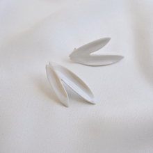 Load image into Gallery viewer, Two white leaves earrings. Stunning white porcelain earrings on a soft silk background. 