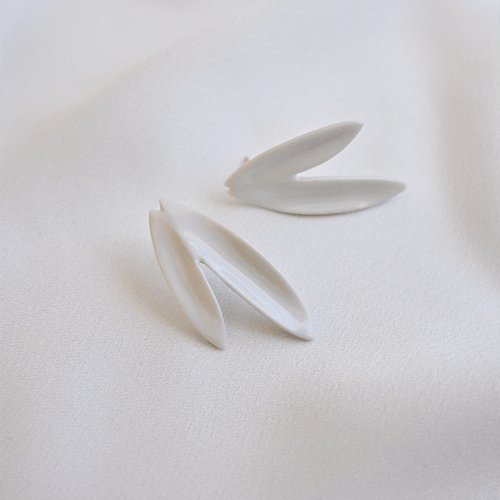 Two white leaves earrings. Stunning white porcelain earrings on a soft silk background. 