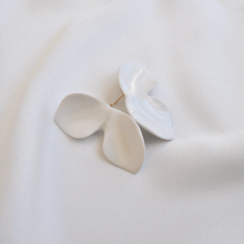 Load image into Gallery viewer, Product close-up: white porcelain earrings. Composition reminds a butterfly shape. White soft silk backgroun