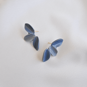 Three petals porcelain earrings. Timeless jewellery on a grey background.