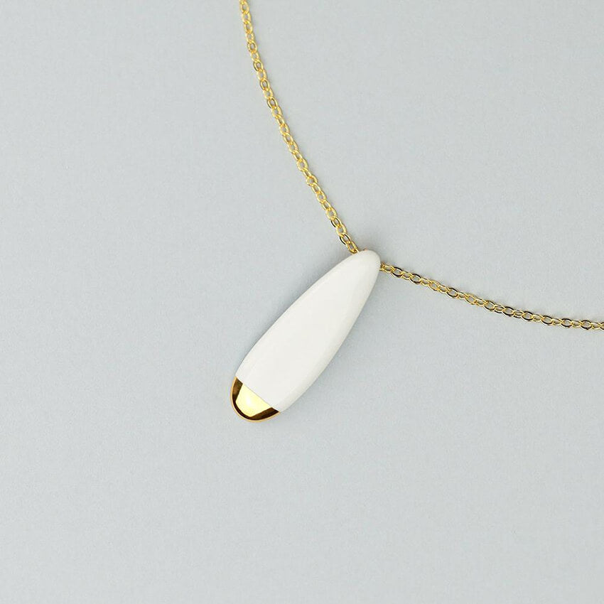 Zoom in: beautiful and delicate white porcelain pendant on an elegant golden chain.