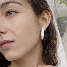 Load image into Gallery viewer, Close-up of a young woman wearing a ceramic earring. 