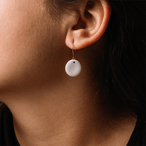 Beautiful close-up of a white porcelain earring. Minimal style. 