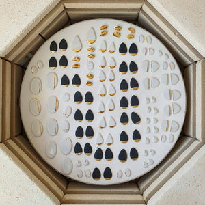 Kiln layer full of white and black porcelain pieces with gold details. 
