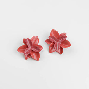 Truly sculptural design: red porcelain earrings with two shades of red. Each petal is an impressive work of art. Soft grey background.