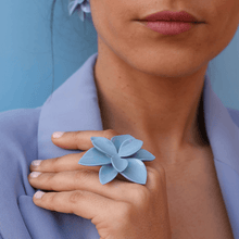 Load image into Gallery viewer, Woman wearing a blue blazer on a blue background. She&#39;s brunette. Colorful image emphasizing the beautiful blue ring.