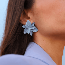 Load image into Gallery viewer, A stylish woman wearing a blue blazer and showcasing a pair of blue porcelain earrings against a matching blue backdrop.