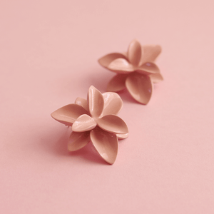 A close-up view of soft pink porcelain flowers, showcasing their intricate details and delicate beauty. Soft pink background. 