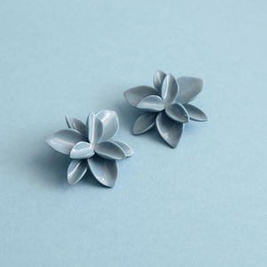 Floral porcelain blue earrings. Romantic handcrafted flowers turned into beautiful earrings on a blue background. 