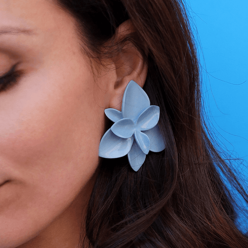 A vibrant light blue porcelain flower earring, showcasing its intricate design and elegant craftsmanship.