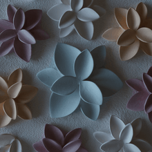 Load image into Gallery viewer, Raw porcelain flowers ready to be fired. Orange, white, and rose flowers surround a bigger blue one. It seems like a sublime porcelain garden.