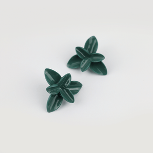 Green flower-shaped porcelain earrings displayed on a light background, highlighting their elegance and craftsmanship.
