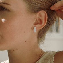 Load image into Gallery viewer, Young woman wearing tiny white and gold stud earrings. 