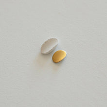Load image into Gallery viewer, Two porcelain pieces aside: unpolished raw porcelain vs smooth, shiny gold final jewel.