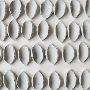 At the studio: raw porcelain petal-shaped pieces drying for days, before being polished.