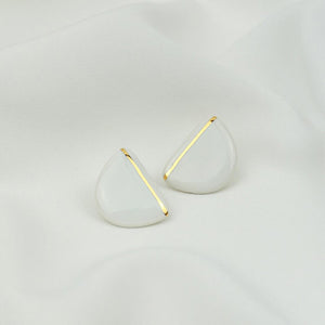 White and gold porcelain earrings. Clean background. 