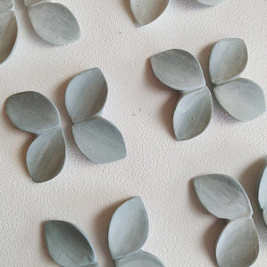 A multitude of petals exquisitely crafted by expert hands. Handmade light blue earrings in the making. 