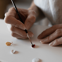 Load image into Gallery viewer, Ceramic&#39;s workshop: handcrafted porcelain pieces that will turn into beautiful gold earrings. Artisan hands painting gold details with a brush. 