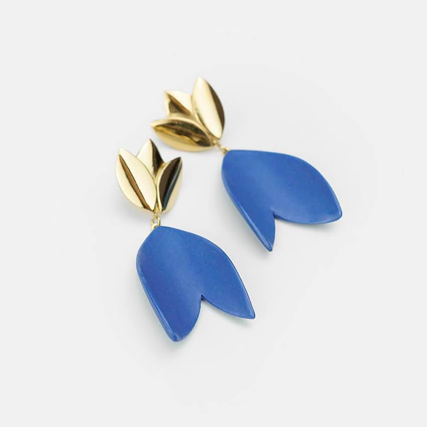 Dangle earrings with exclusive design. Strong blue porcelain earrings. Product close-up. Bright background. 