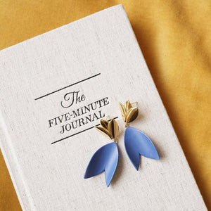 Strong blue porcelain earrings and a book (The Five-Minute Journal).