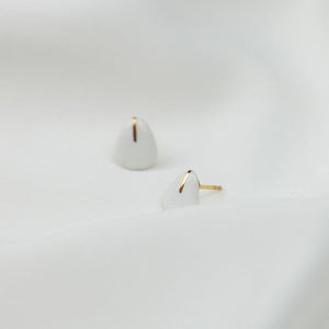 Product capture: white porcelain jewels. White earrings hand-painted with pure liquid gold. Clean background and light.