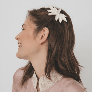 Nine petals hair piece made of porcelain. Handmade jewelry design. Smiling young lady wearing a unique jewellery piece. 