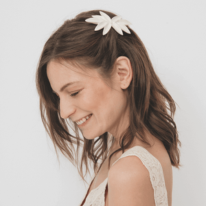 Nine petals hair piece made of porcelain. Handmade jewelry design. Smiling young lady wearing a unique jewellery piece.